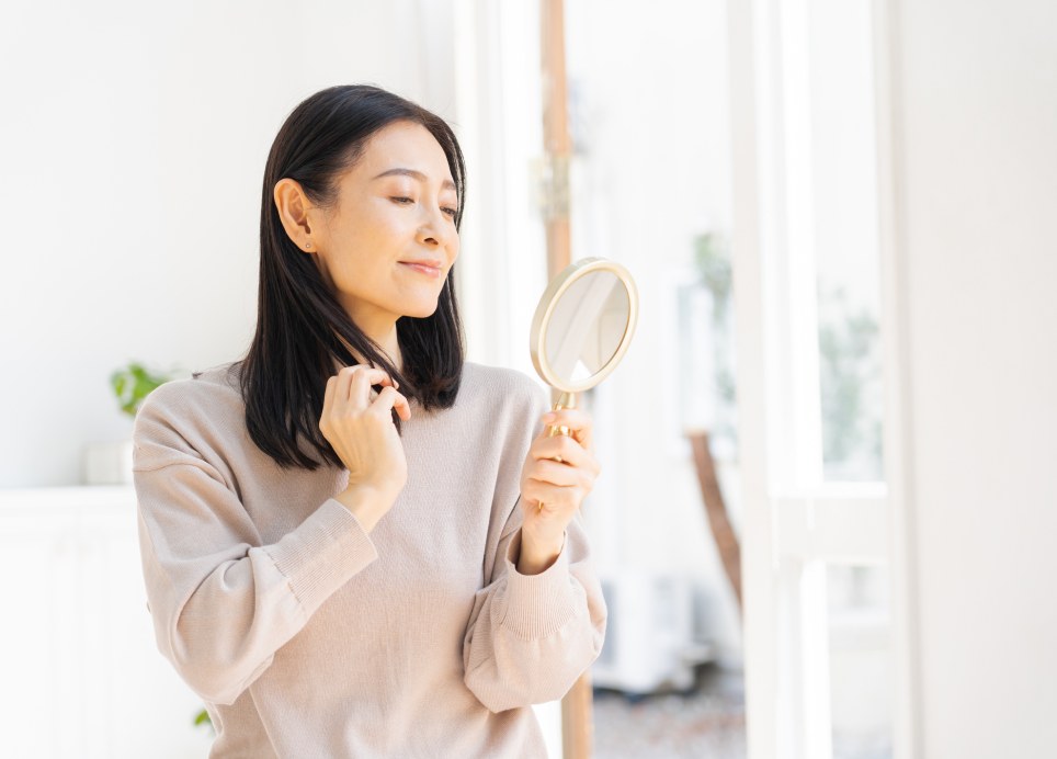 手鏡で仕上がりを確認する女性